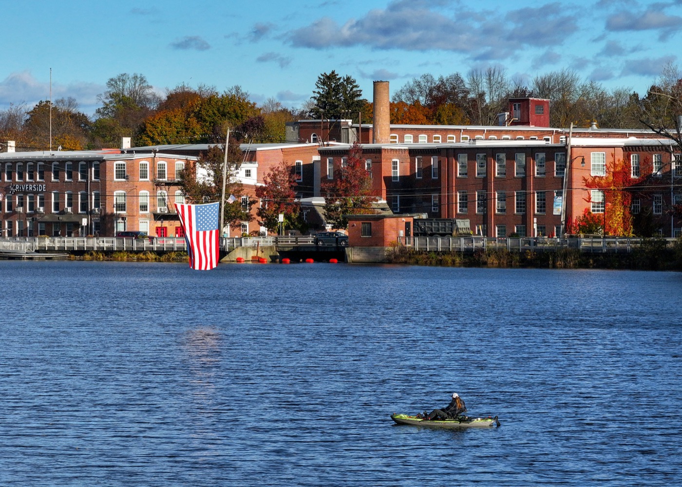 The brick Nashawannuck mill buildings reflected in the water in Easthampton, Massachusetts